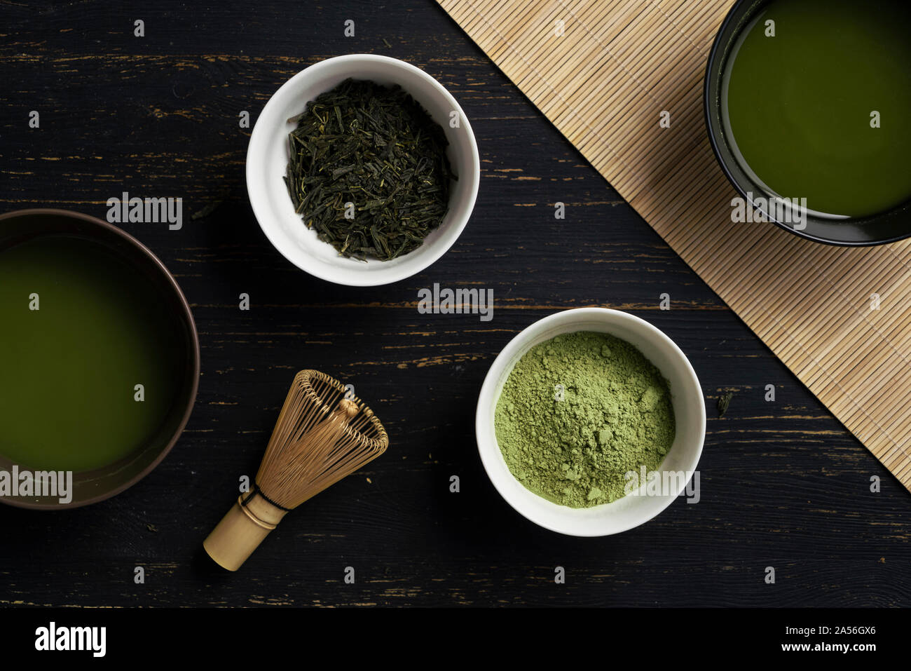 Still life of matcha tea preparation with whisk and bowls of matcha tea and tea powder, overhead view Stock Photo
