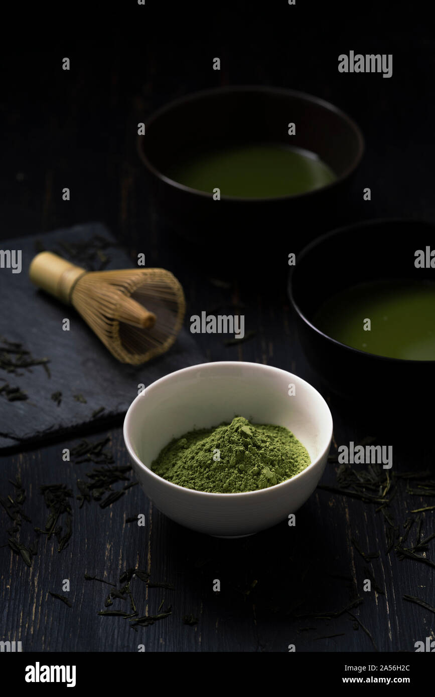 Still life of matcha tea preparation with whisk and bowls of matcha tea and tea powder, low key Stock Photo