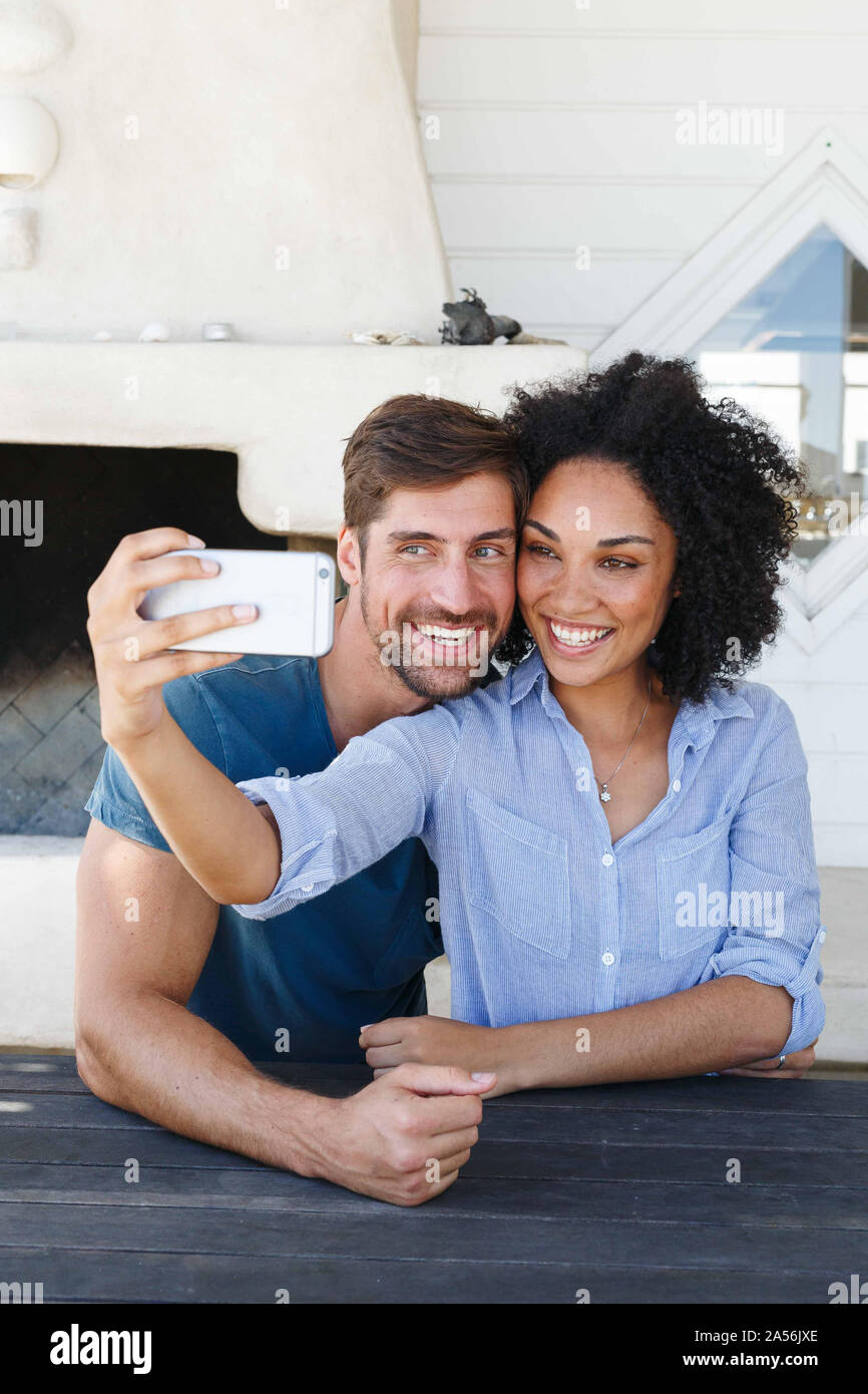 Couple taking selfie in beach house Stock Photo