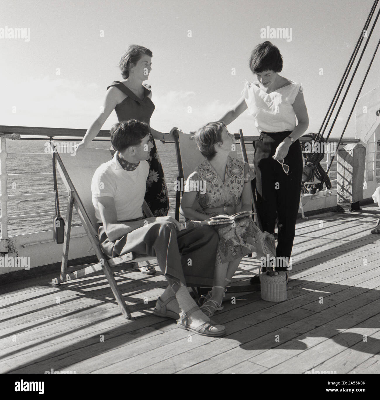 1960s, historical, four young adult passengers outside in the open-air on the wooden deck on board the Sagafjord cruise ship. Stock Photo