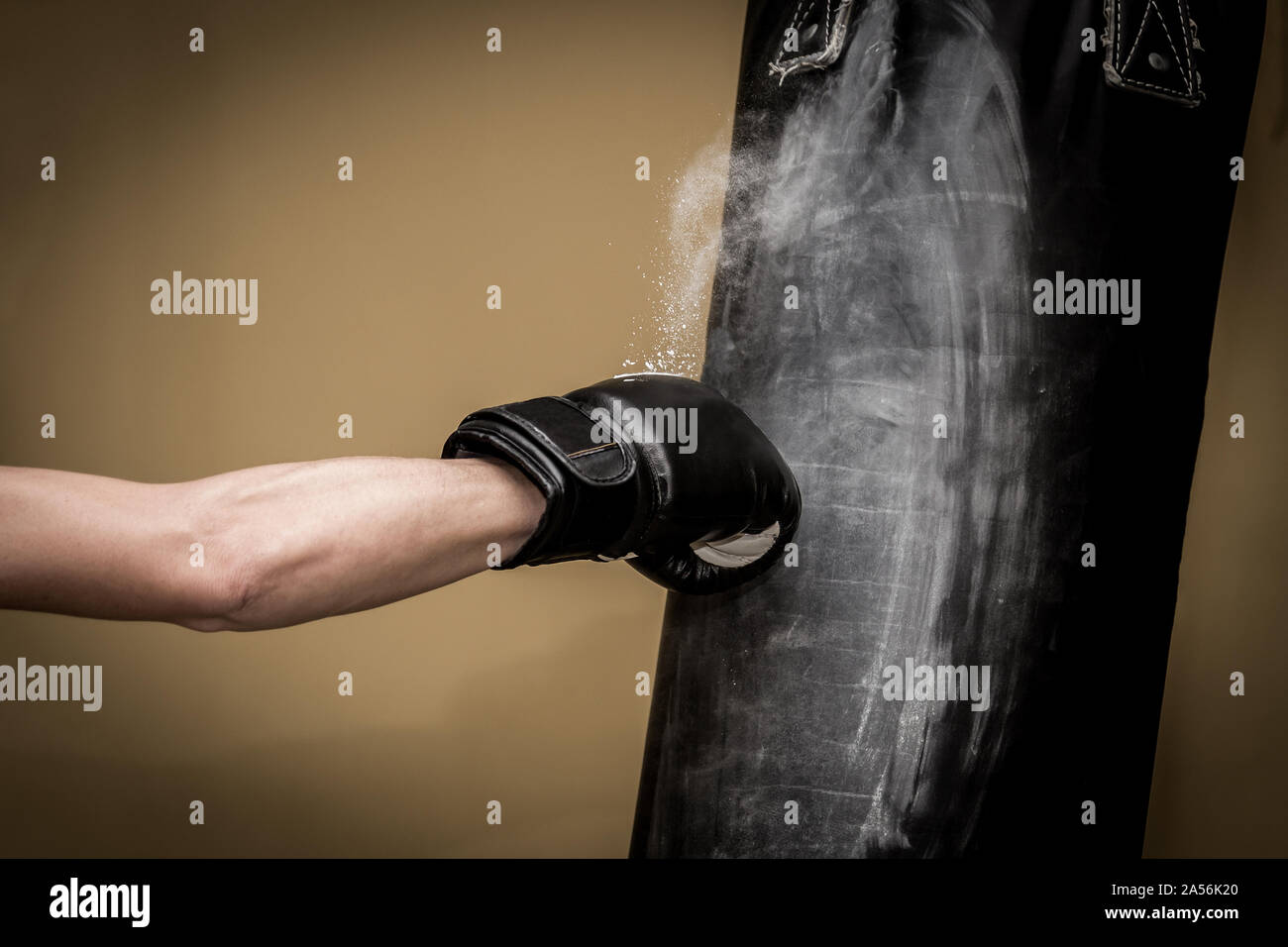 Hand of boxer and punching bag over yellow background. Stock Photo