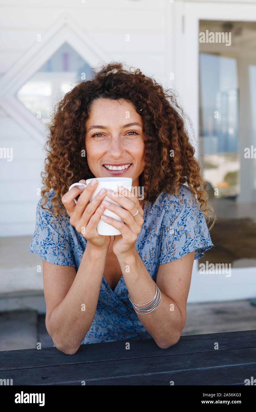 Woman enjoying hot drink clasped in hands at home Stock Photo