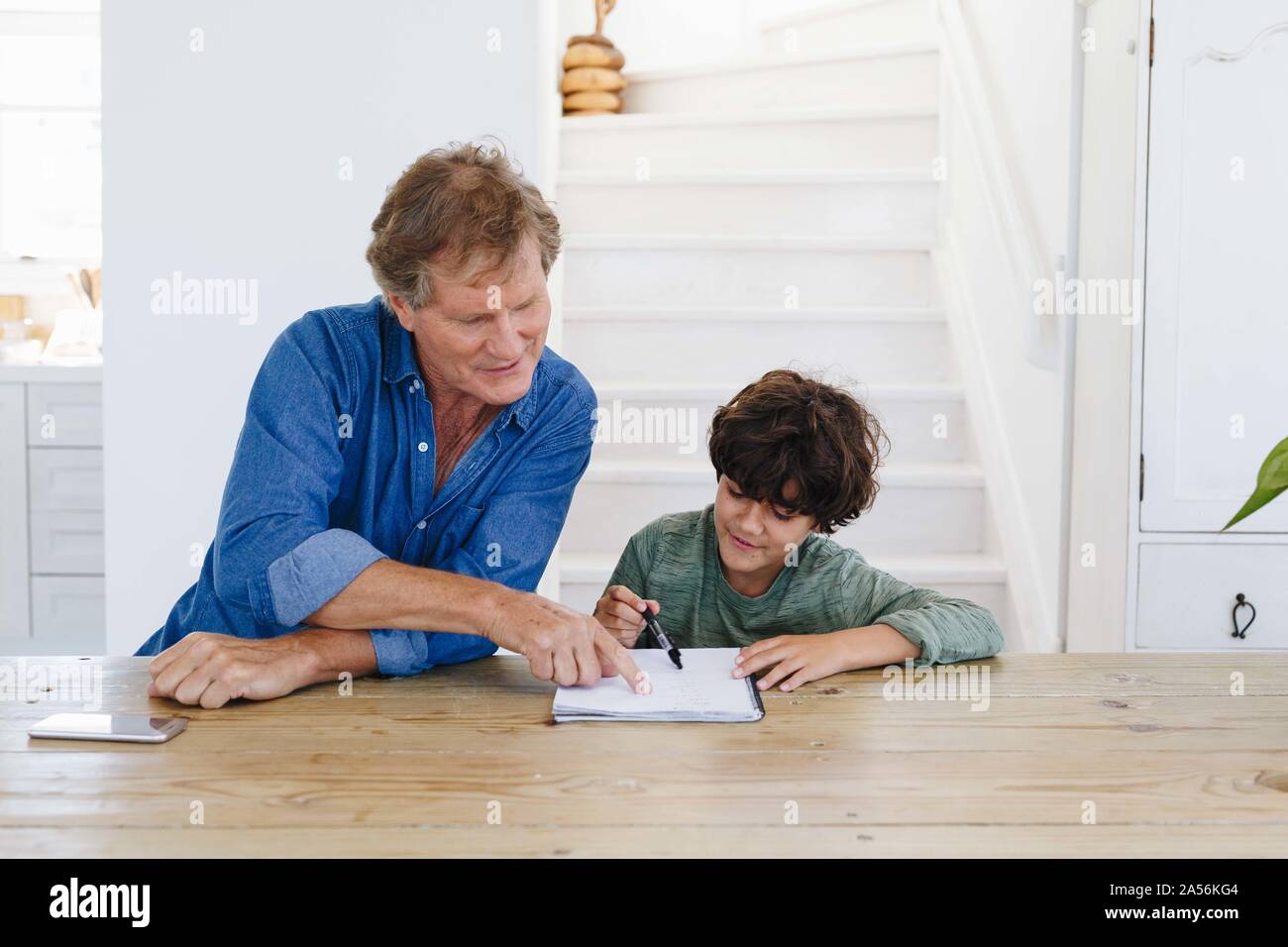 Father helping son with homework at home Stock Photo
