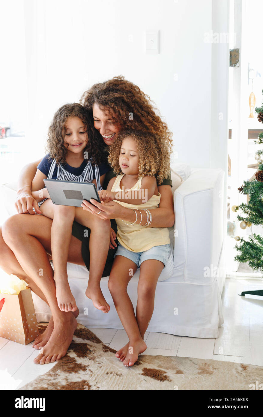 Mother and daughters using digital tablet at home Stock Photo