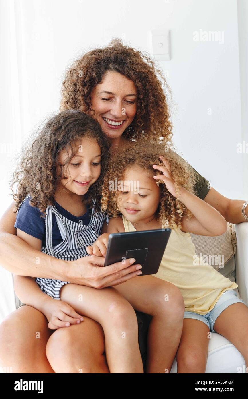 Mother and daughters using digital tablet at home Stock Photo