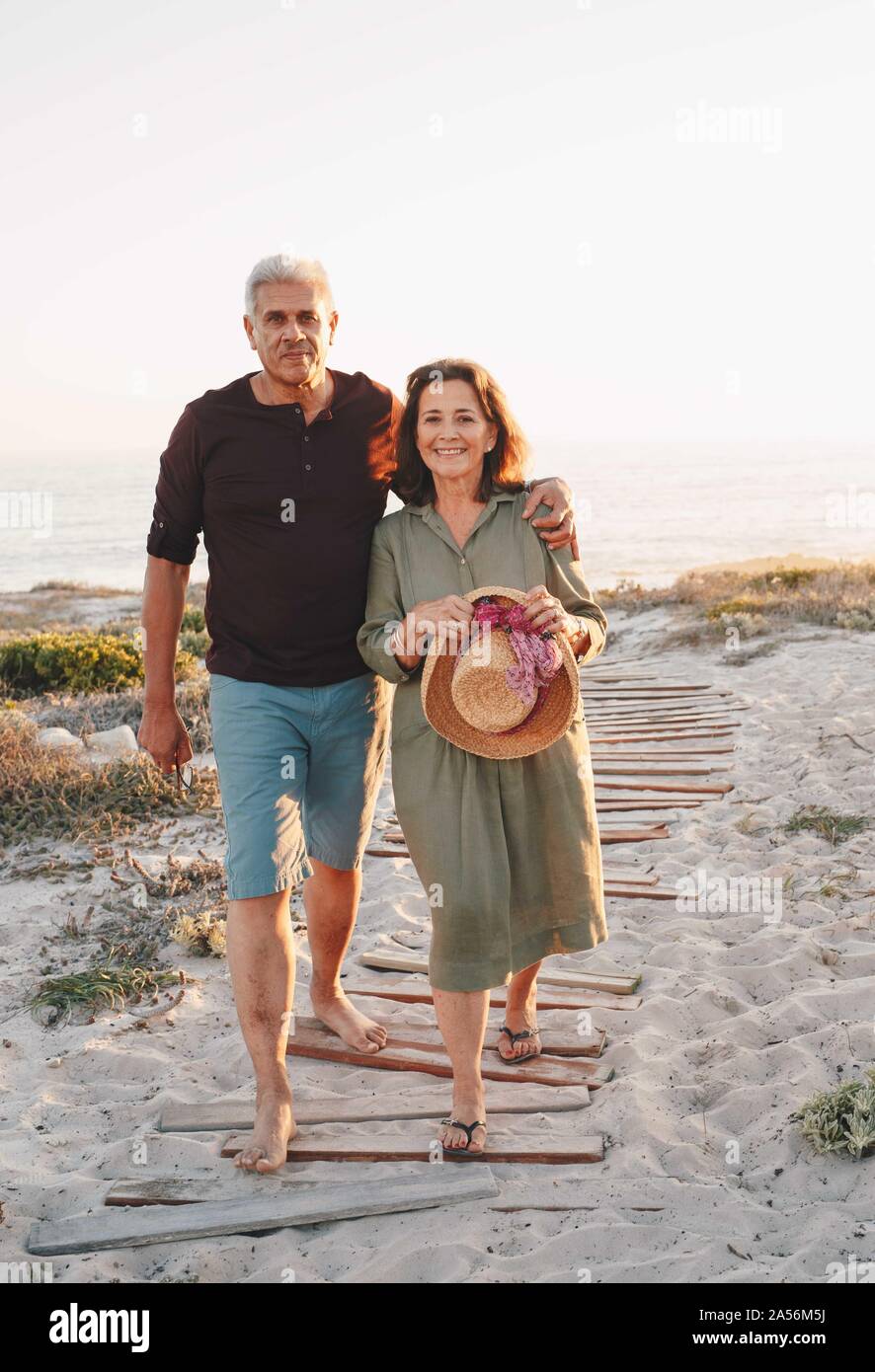 Senior couple taking walk on beach Stock Photo