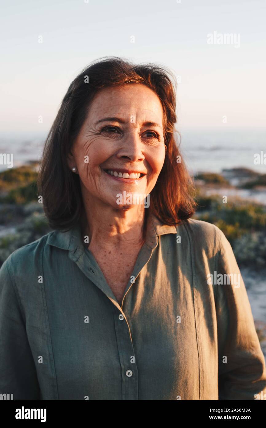 Senior woman enjoying sun on beach Stock Photo