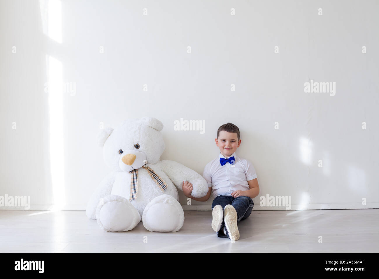 A boy holds a white teddy bear toy Stock Photo - Alamy