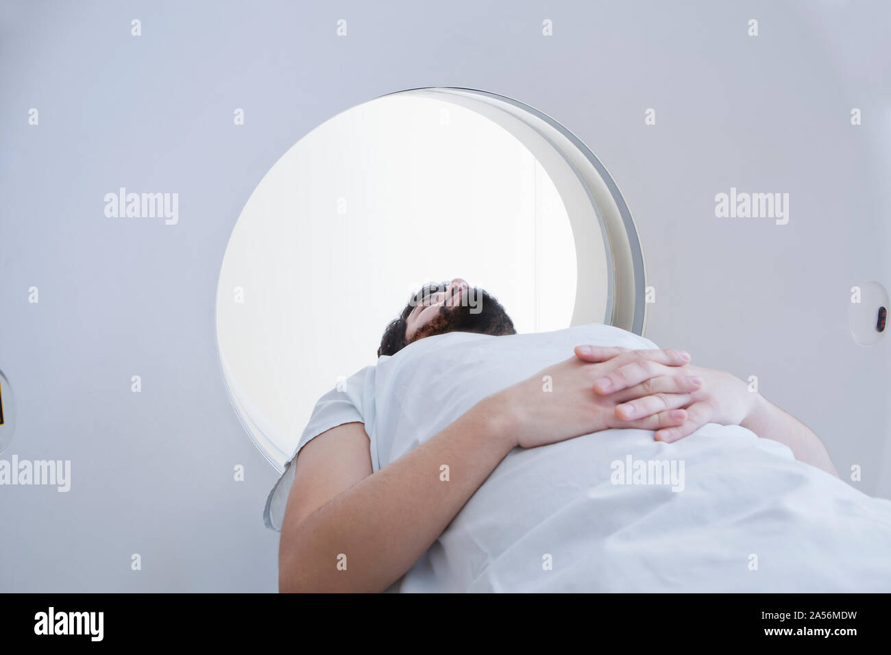 Young male patient having a CT scan in radiology department Stock Photo