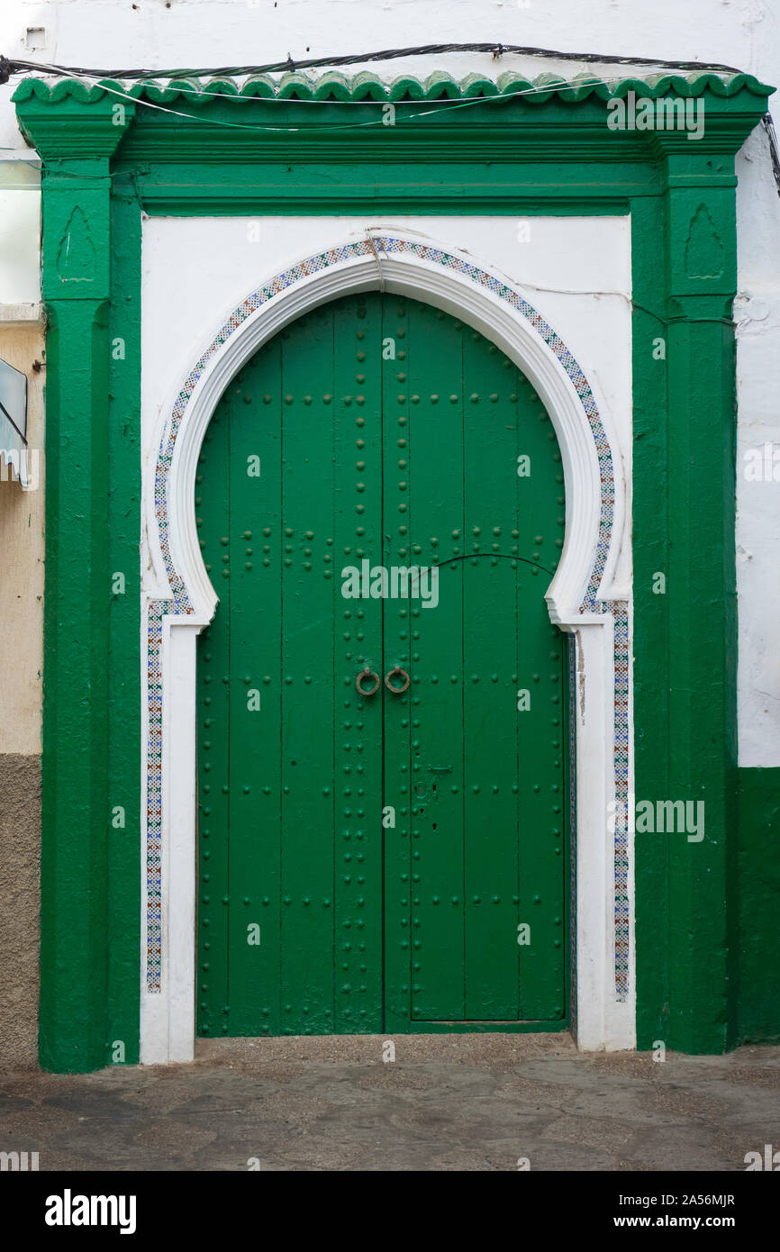 Green painted wooden traditional door and decoration in the medina of Asilah, Morocco Stock Photo