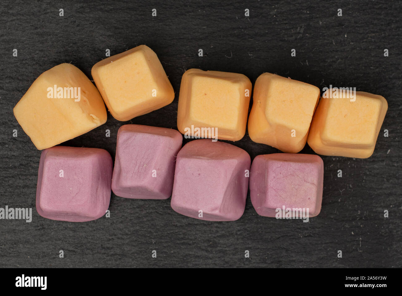 Lot of whole arranged soft pastel candy flatlay on grey stone Stock Photo