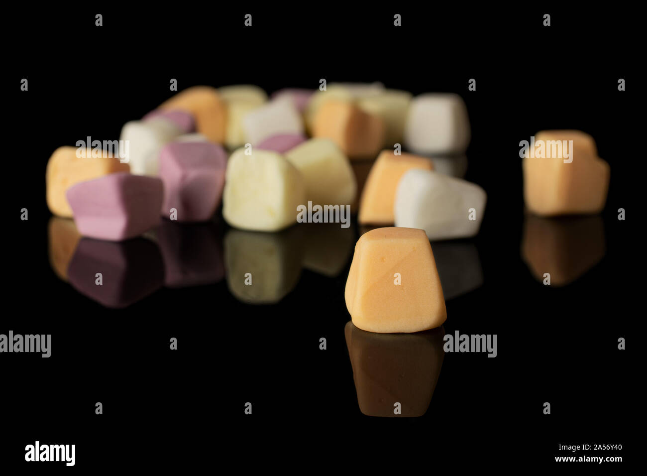 Lot of whole disordered soft pastel candy isolated on black glass Stock Photo