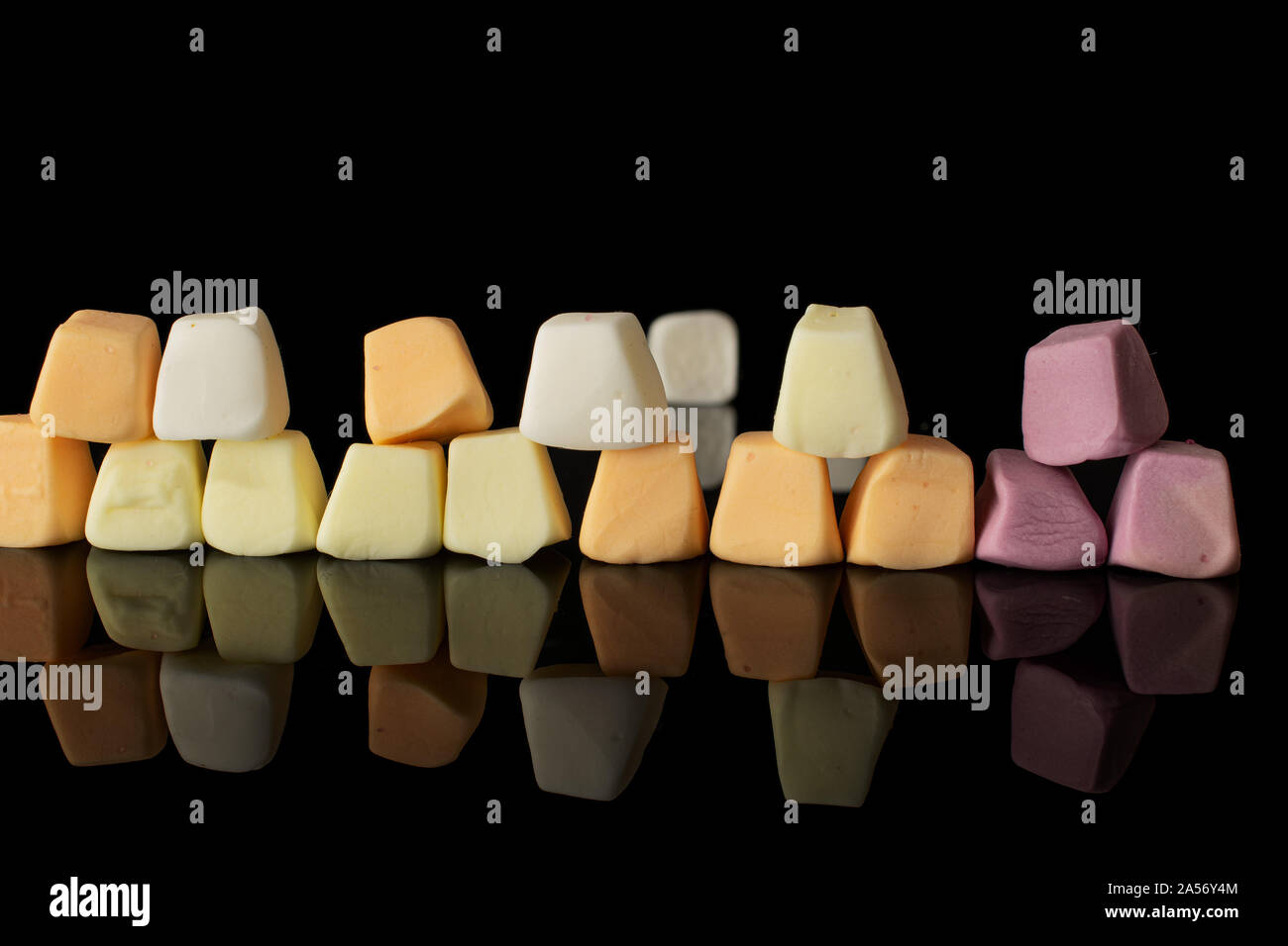 Lot of whole arranged soft pastel candy isolated on black glass Stock Photo