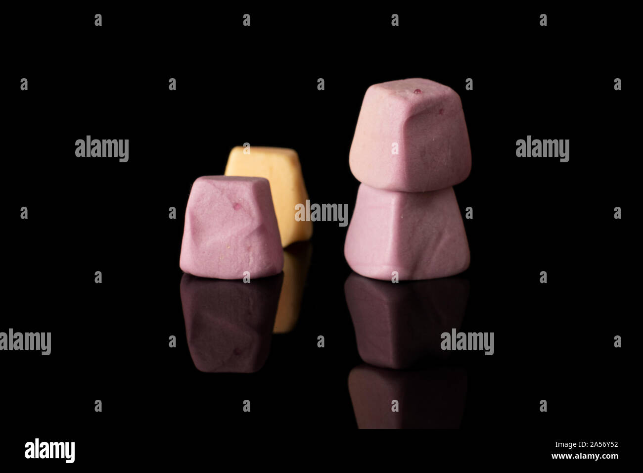 Group of four whole soft pastel candy isolated on black glass Stock ...