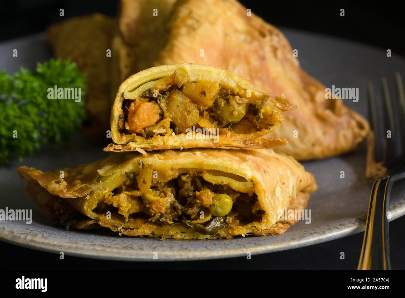 Samosas a spicy blend of vegetables or meat wrapped in a deep fried triangular pastry parcel a popular snack in the Middle East and South Asia Stock Photo