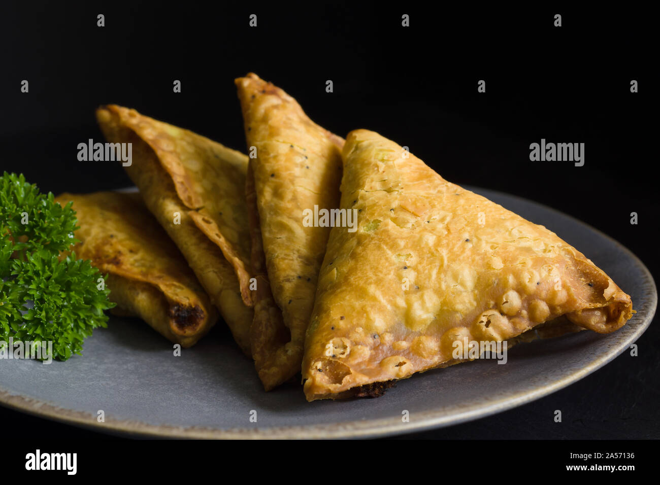 Samosas a spicy blend of vegetables or meat wrapped in a deep fried triangular pastry parcel a popular snack in the Middle East and South Asia Stock Photo