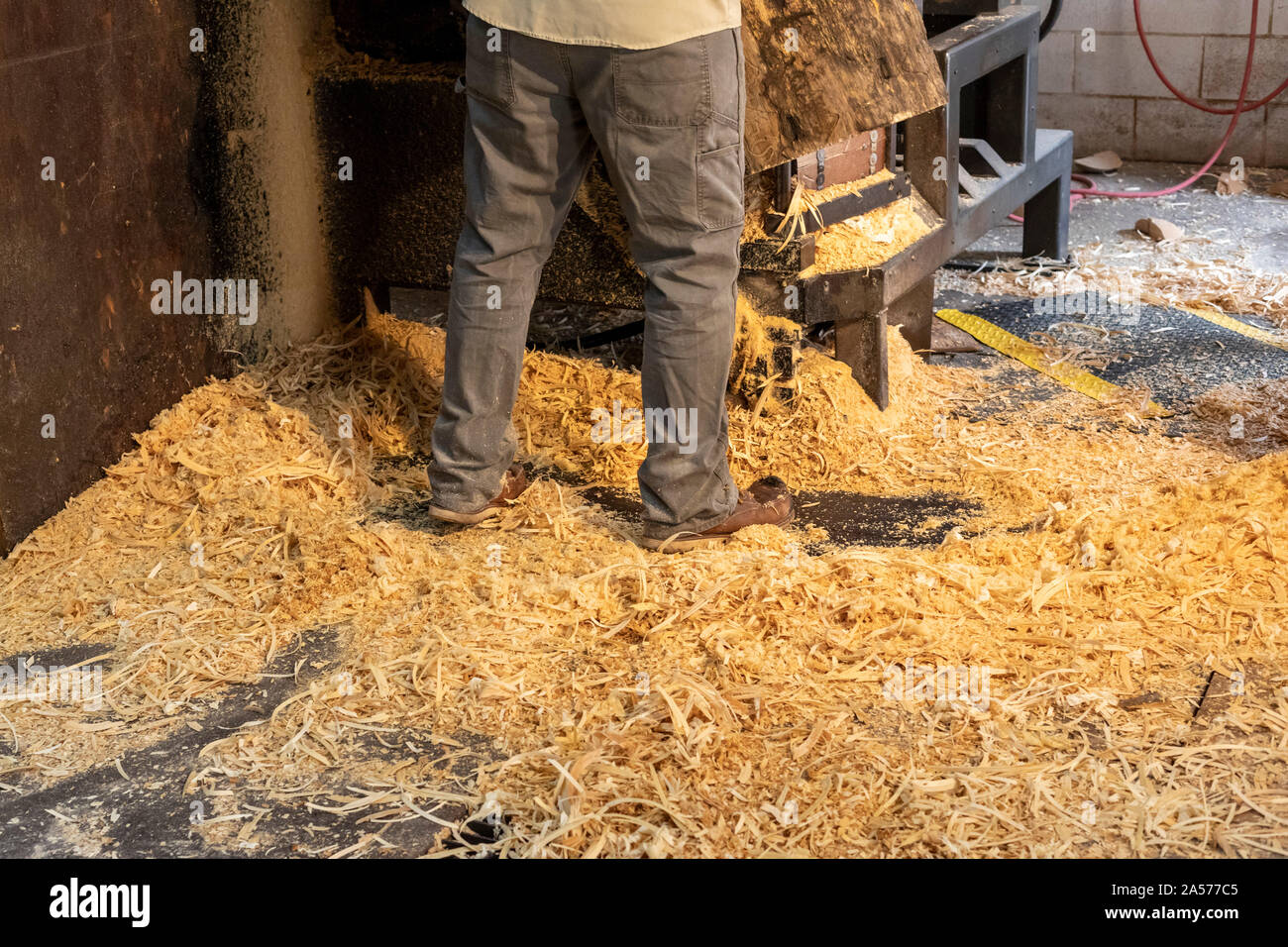 Holland, Michigan - A worker stands in wood shavings as he uses a lathe to shape wood bowls from a block of wood at the Holland Bowl Mill. Stock Photo