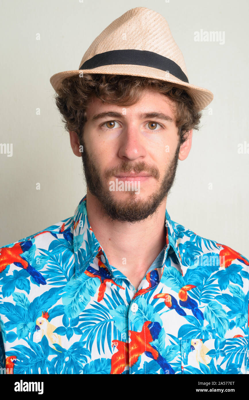 Face of young bearded tourist man with curly hair wearing hat Stock Photo -  Alamy