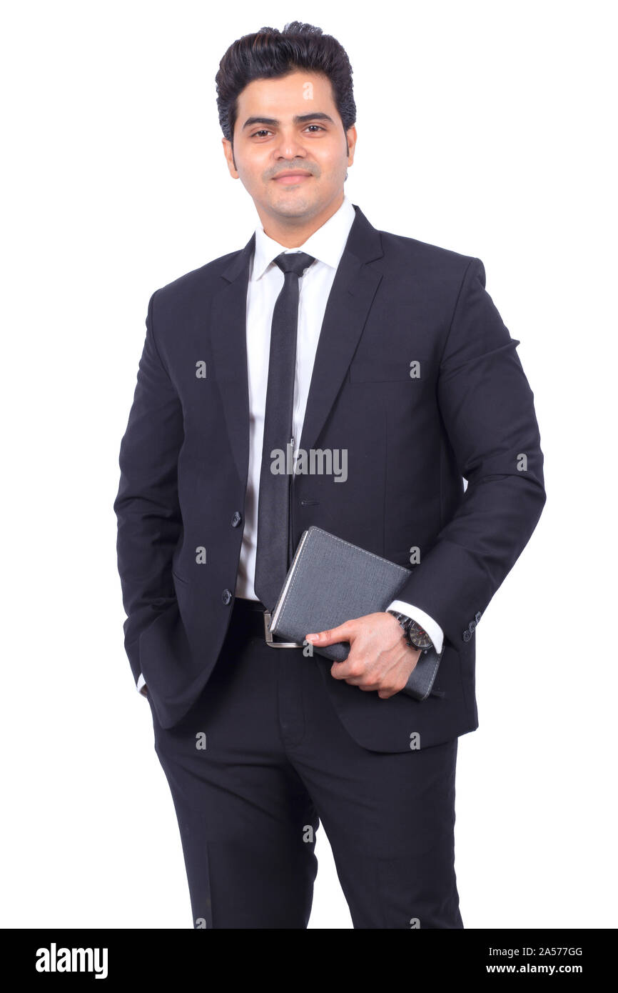 Portrait of handsome young businessman holding diary. Confident male professional standing on white background. He is wearing elegant suit. Stock Photo
