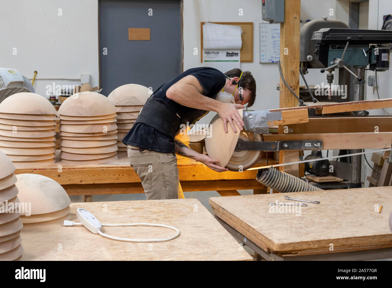Holland, Michigan - A worker sands wood bowls at the Holland Bowl Mill. The factory turns logs into bowls and other wood products. Stock Photo