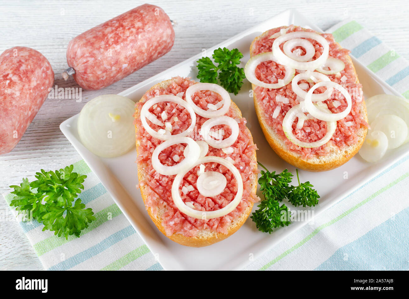 german food mett ground pork, raw meat with onion and parsley Stock Photo