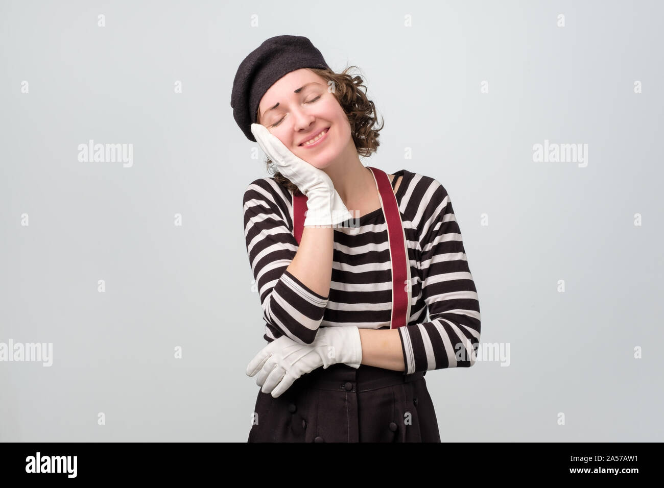 mime woman sleeping tired dreaming with hands together while smiling Stock Photo