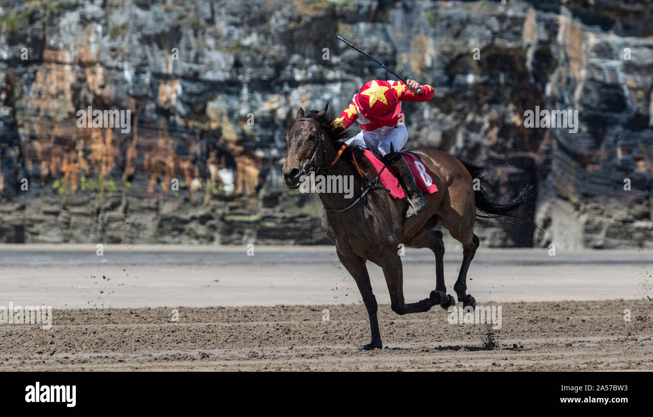 Jockey using a whip on a race horse, Horse raceing action on the beach