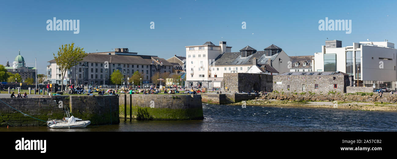GALWAY CITY, IRELAND - 5th May, 2018: People enjoying a sunny spring day along the bank of Corrib river in the Claddagh area of Galway city, View of G Stock Photo