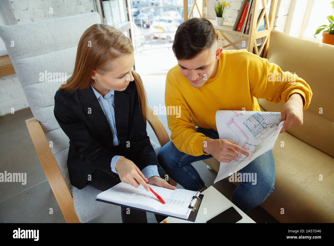 Interior designer working with young couple. Lovely family and ...