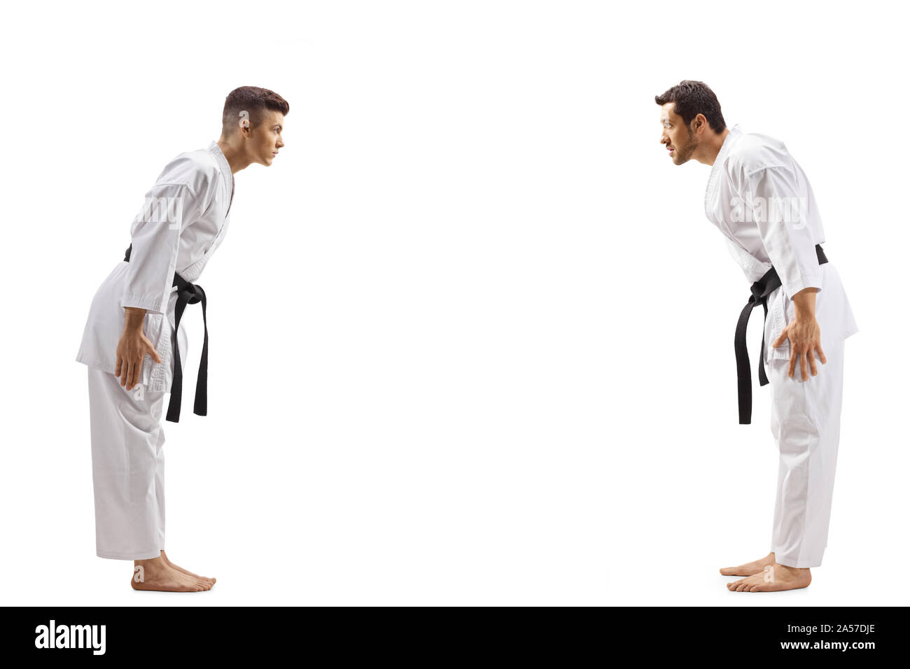 Full length profile shot of young men in karate kimonos bowing to each other isolated on white background Stock Photo