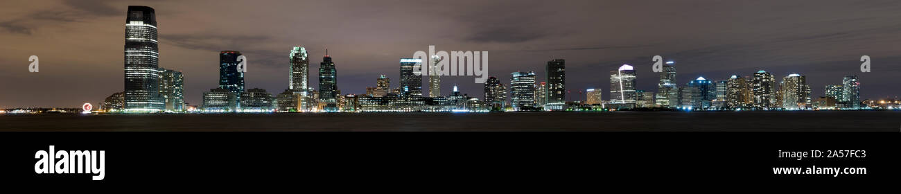 Buildings in a city lit up at night, Hudson River, Jersey City, Hudson County, New Jersey, USA Stock Photo