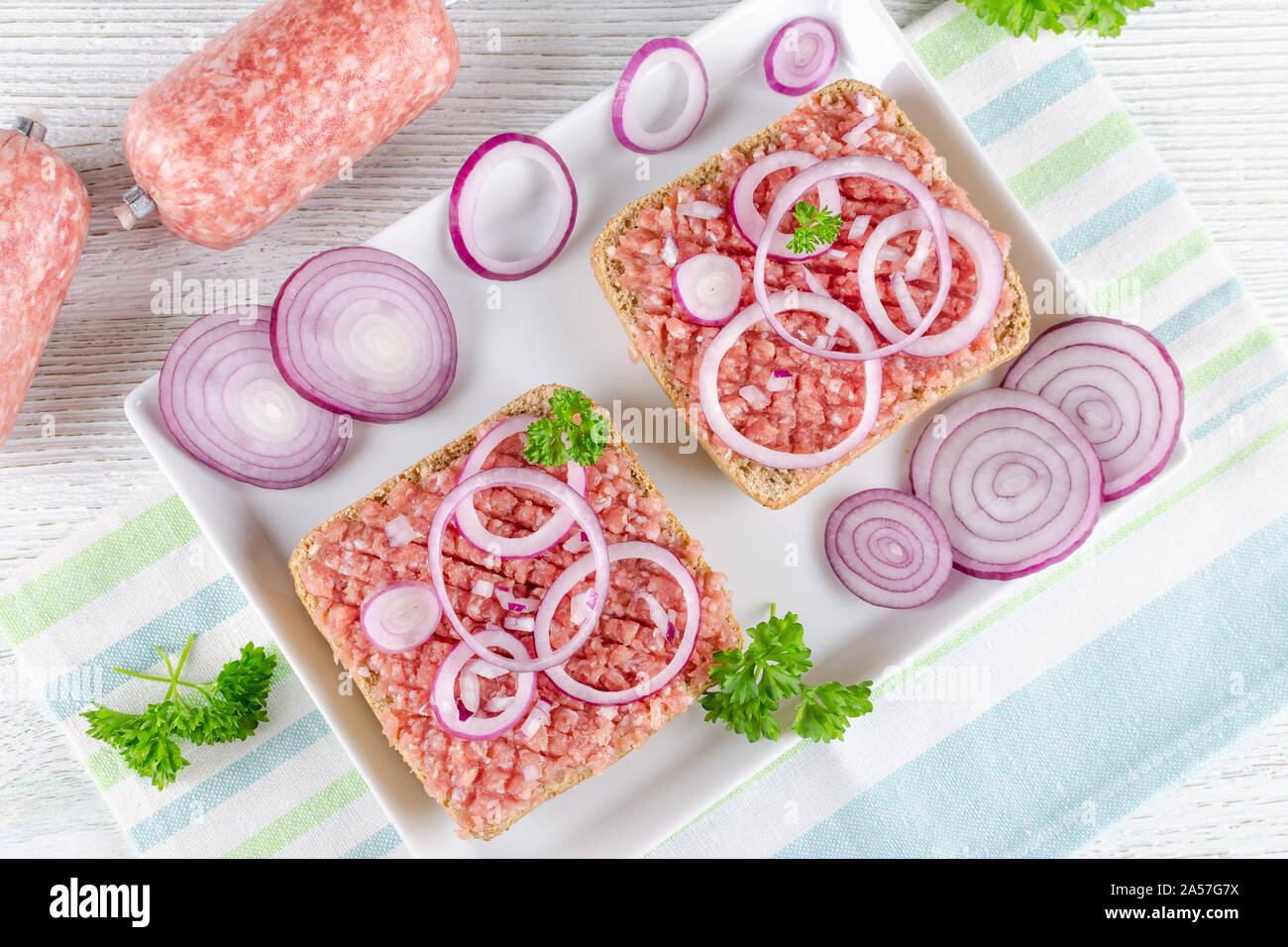 german food mett ground pork, raw meat with onion and parsley Stock Photo