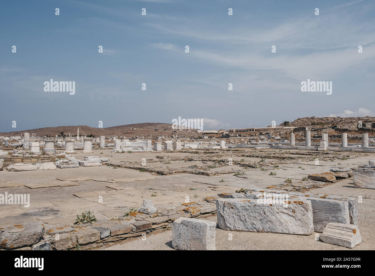 Ruins of agora on the historic island of Delos, Greece, Archaeological Museum of Delos on the background. Stock Photo