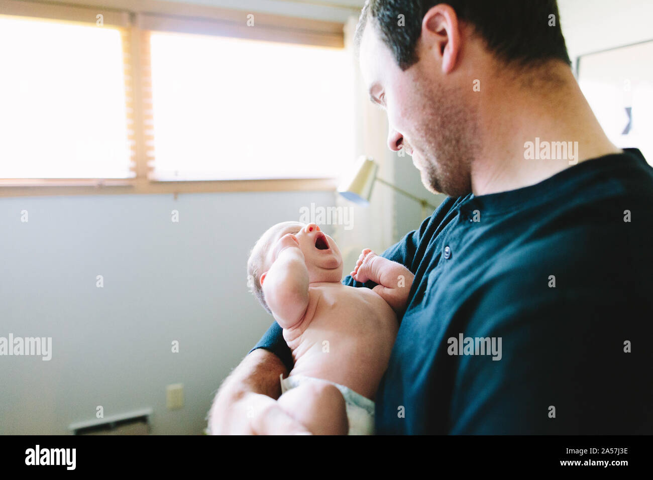 A new dad holds his tired newborn son Stock Photo