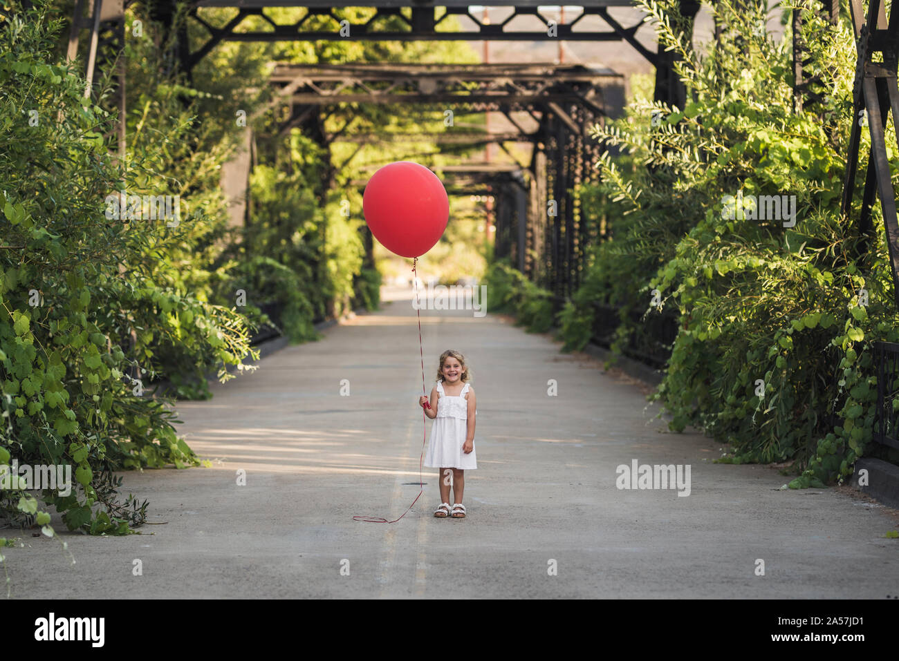 Smiling girl with huge red balloon on Steele Canyon Bridge Stock Photo