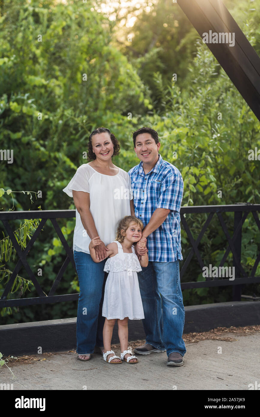 Smiling parents hugging adorable daughter on Steele Canyon Bridge Stock Photo