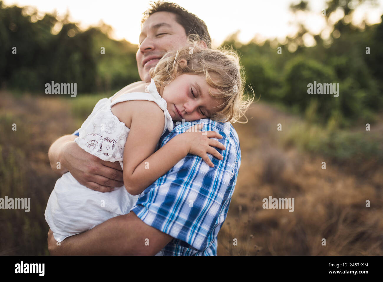 Smiling dad cuddles child sleeping on his shoulder Stock Photo Alamy