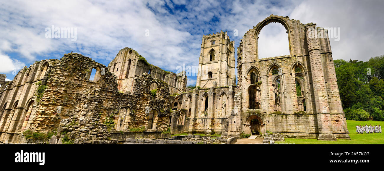 Panorama of Fountains Abbey Cistercian monastery church with Chapter House and Chapel of Altars and group of school children North Yorkshire England Stock Photo