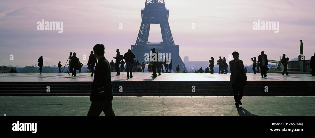 Tourists walking near a tower, Eiffel Tower, Seine River, Paris, Ile-de-France, France Stock Photo