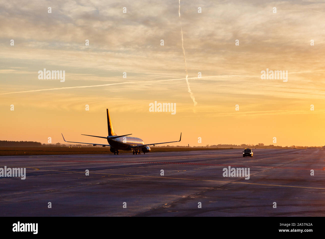 Plane waiting to take off against stunning sunrise Stock Photo