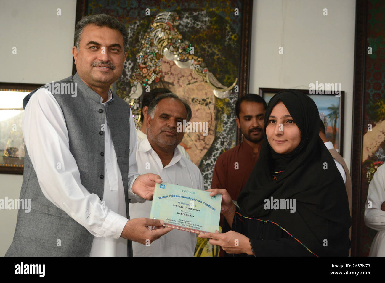 Quetta, Pakistan. 18th Oct, 2019. Secretary for Culture, Tourism and Archive department Mr. Zafar Ali Buledi giving award to fine art student during women expressionism painting exhibition at Art Council Balochistan organized by culture, tourism and archive department government of Balochistan. (Photo by Din Muhammad Watanpaal/Pacific Press) Credit: Pacific Press Agency/Alamy Live News Stock Photo