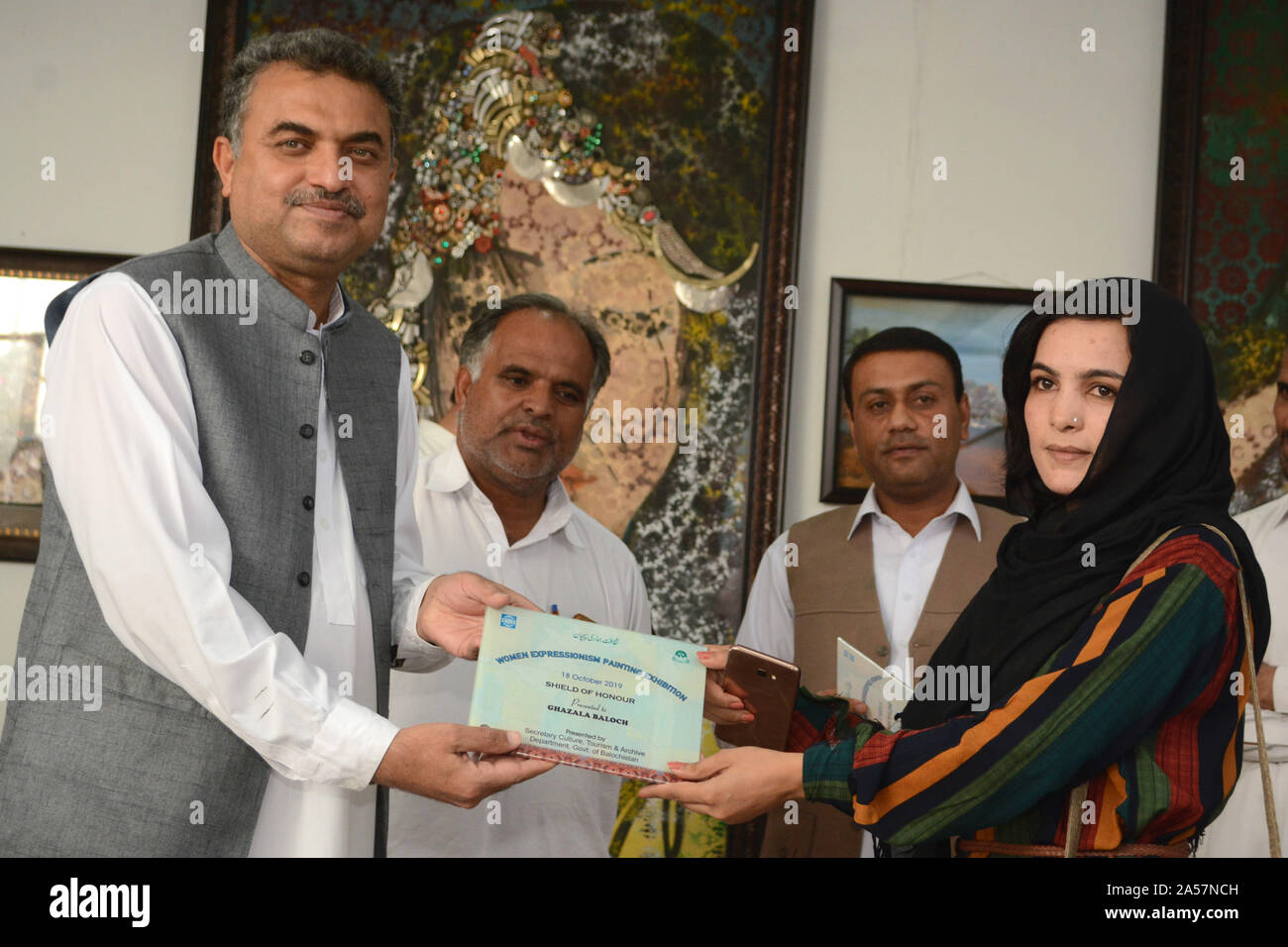 Quetta, Pakistan. 18th Oct, 2019. Secretary for Culture, Tourism and Archive department Mr. Zafar Ali Buledi giving award to fine art student during women expressionism painting exhibition at Art Council Balochistan organized by culture, tourism and archive department government of Balochistan. (Photo by Din Muhammad Watanpaal/Pacific Press) Credit: Pacific Press Agency/Alamy Live News Stock Photo