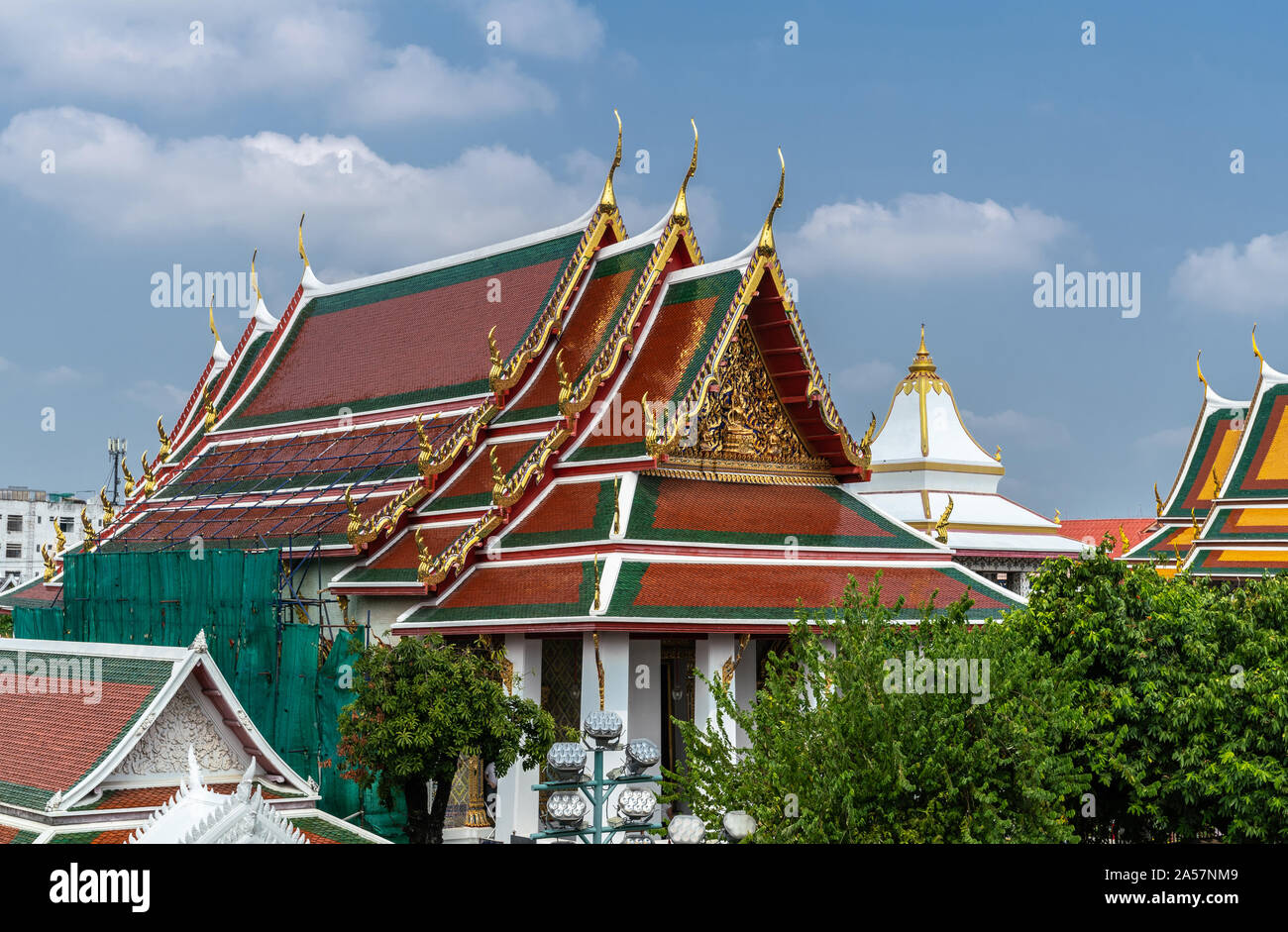 Bangkok city, Thailand - March 17, 2019: Roofs of Ordination hall and offices at Temple of Dawn against blue sky with white clouds. Stock Photo