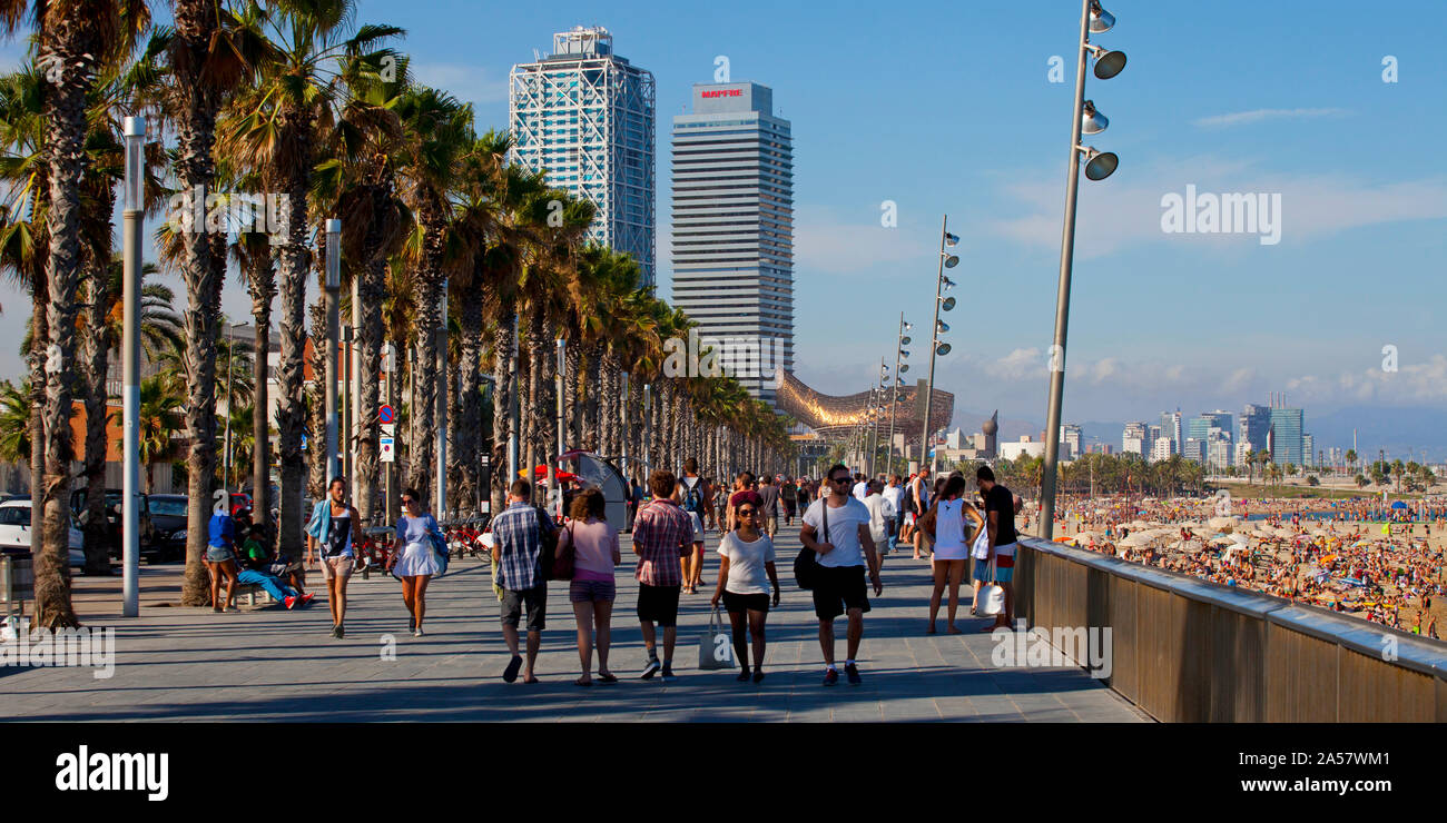 Tourists walking on the promenade, Barceloneta Beach, Barcelona, Catalonia, Spain Stock Photo