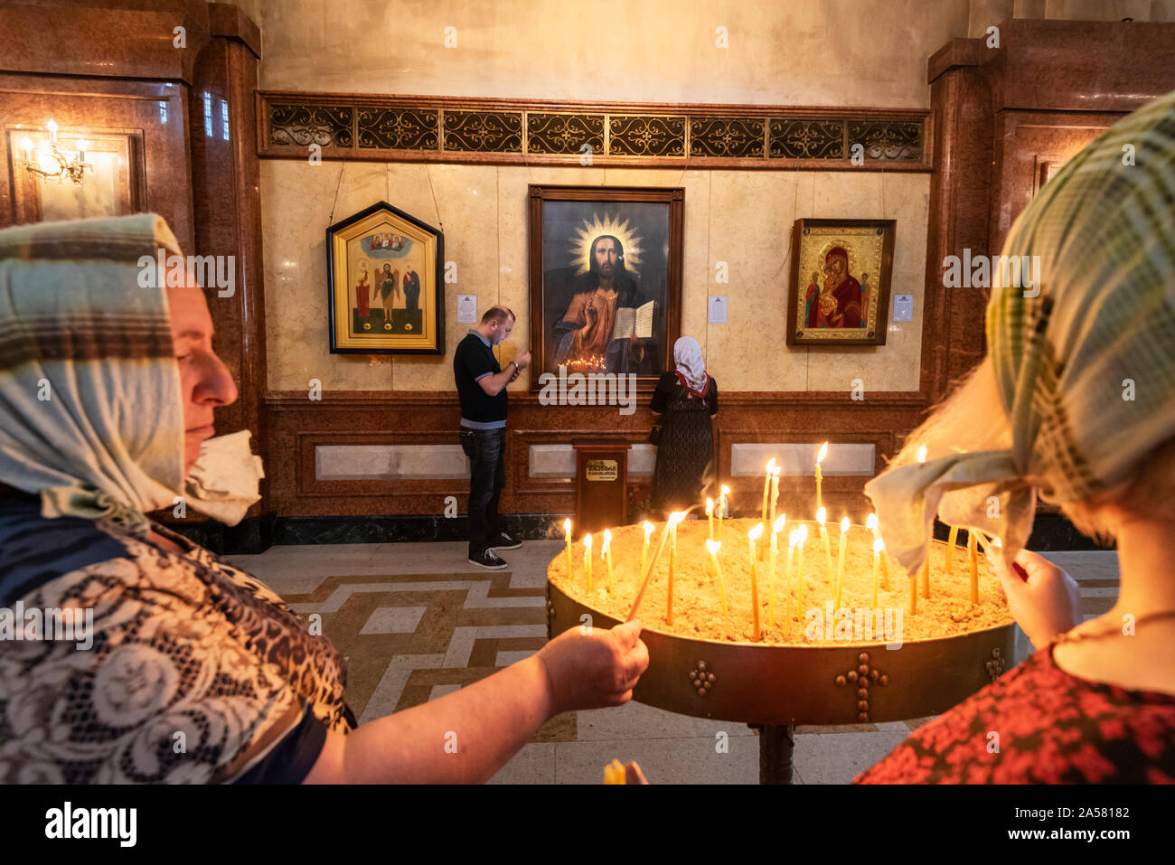 Devotion and faith at the Holy Trinity Cathedral (Tsminda Sameba) of Tbilisi. Georgia, Caucasus Stock Photo