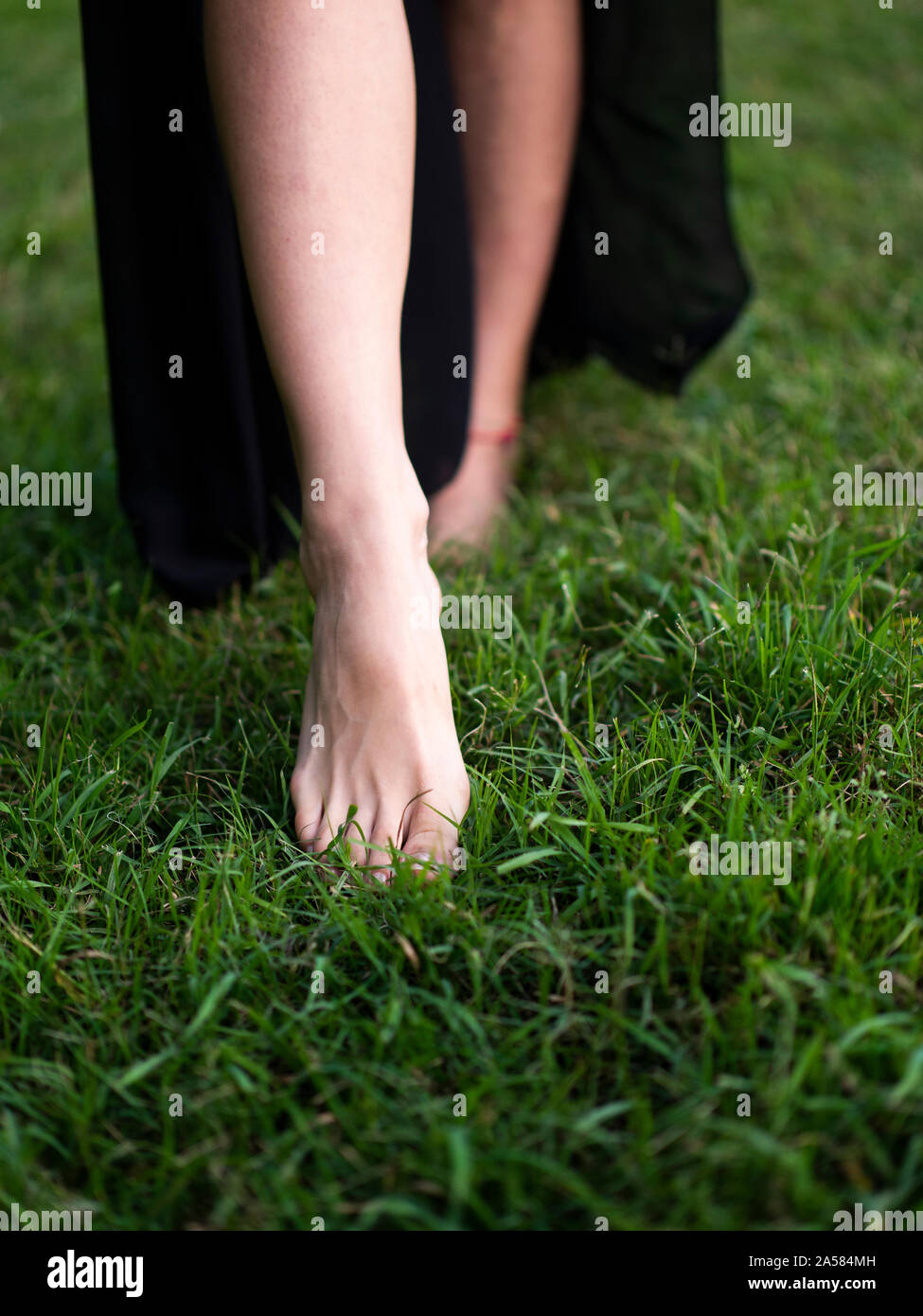 barefoot woman walking in grass Stock Photo