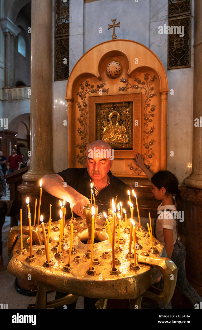 Devotion and faith at the Holy Trinity Cathedral (Tsminda Sameba) of Tbilisi. Georgia, Caucasus Stock Photo