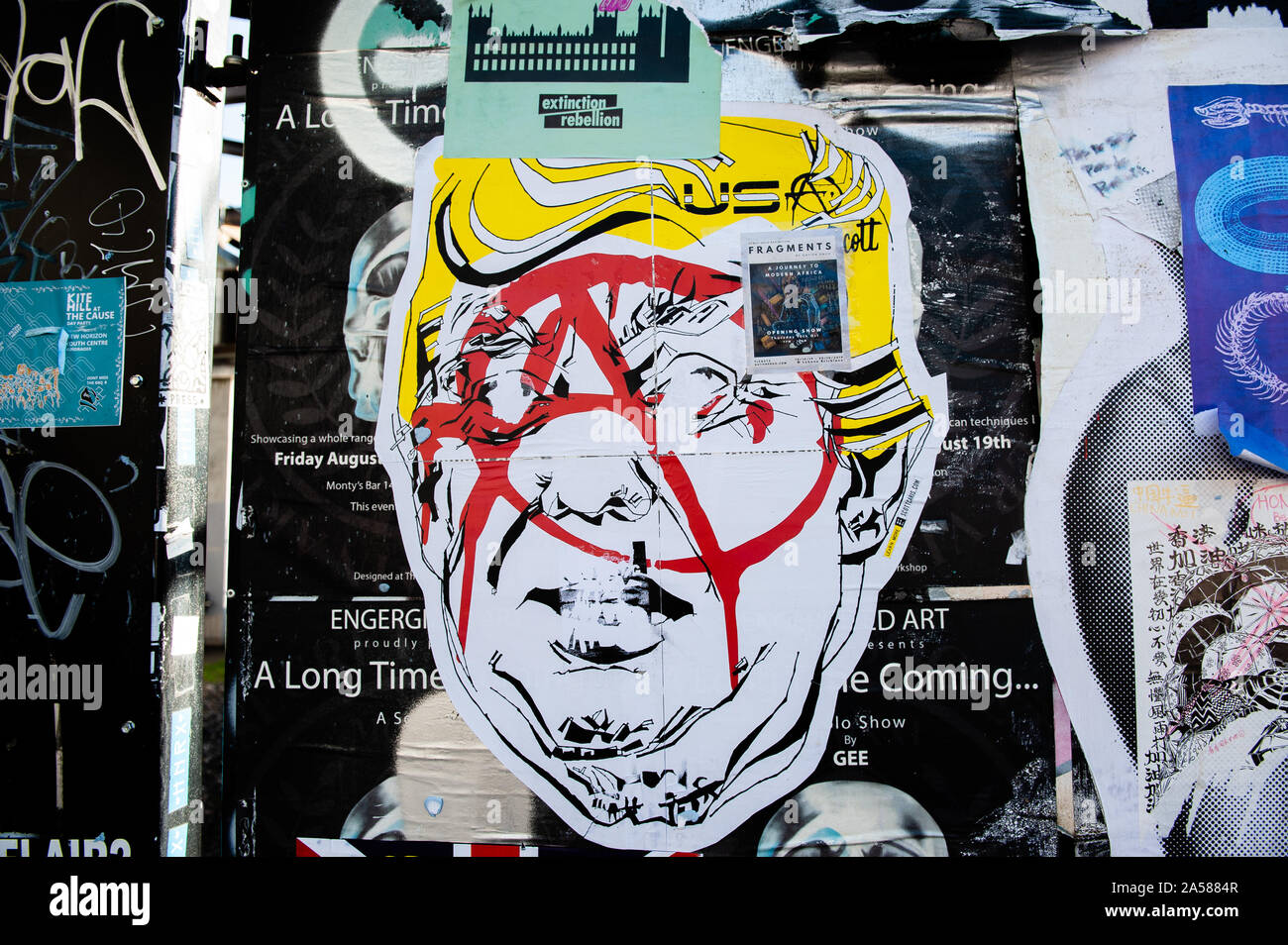 A paste up showing Trump being covered with a anarchist symbol.As the Brexit deadline looms, new murals and paste-ups appear on the streets of London. Brick Lane, in London's east end, is one of the most popular places to find all kind of art around the Brexit. Also in the famous district of Shoreditch, tourists walk and take photos around this political street art. Stock Photo
