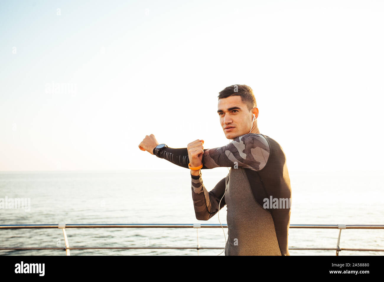 Man in sportswear warming up before running Stock Photo