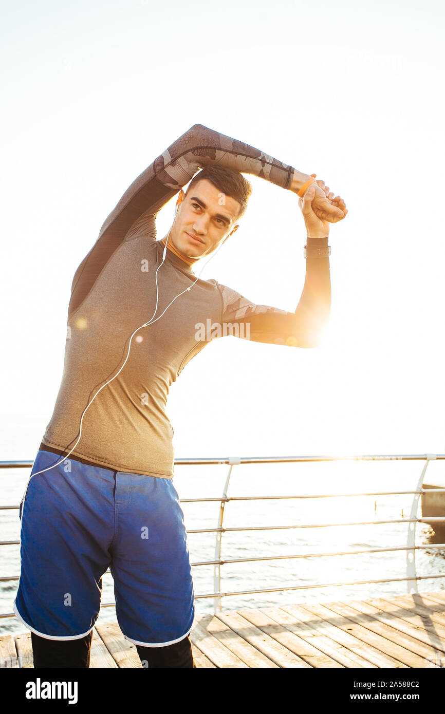 Fit handsome man  warming up in preparation for a workout run. Stock Photo